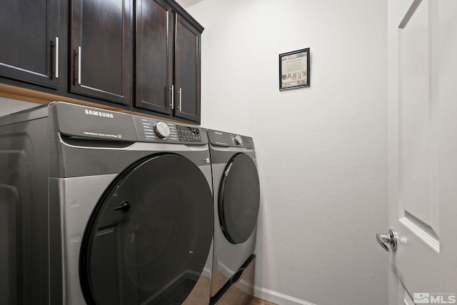 laundry area with cabinet space, washing machine and dryer, and baseboards