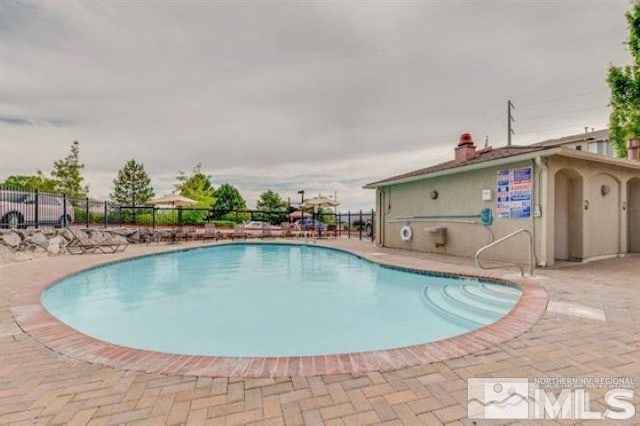 community pool featuring fence and a patio area