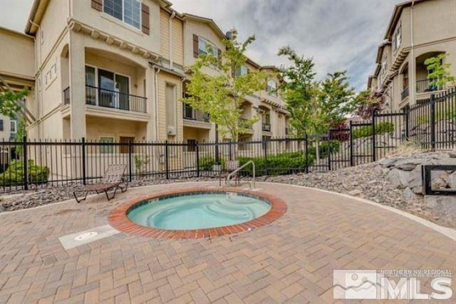 view of pool with fence and a community hot tub
