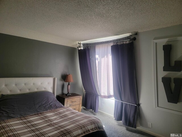 bedroom with light carpet and a textured ceiling