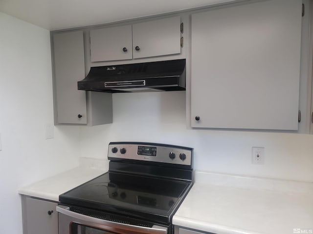 kitchen featuring stainless steel electric range, gray cabinets, under cabinet range hood, and light countertops