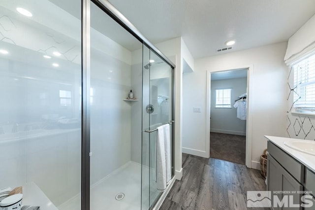 full bathroom featuring wood finished floors, a stall shower, healthy amount of natural light, and vanity