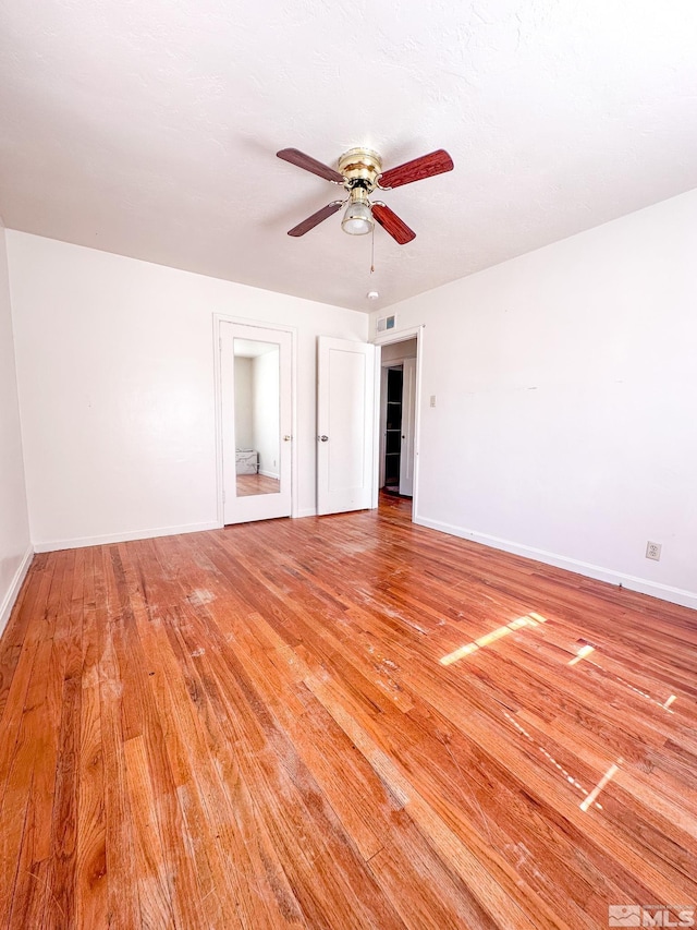 unfurnished bedroom featuring light wood finished floors, baseboards, and a ceiling fan