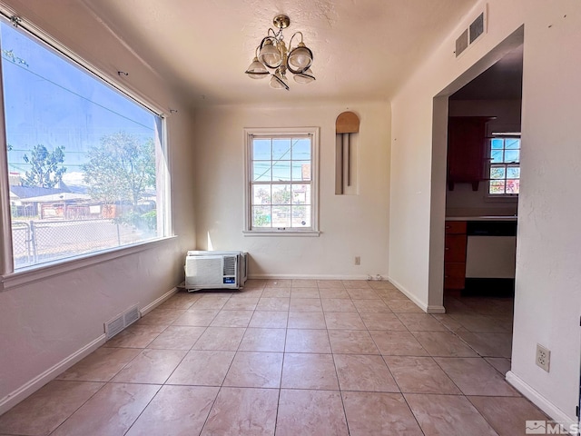 unfurnished dining area featuring a chandelier, light tile patterned floors, and baseboards