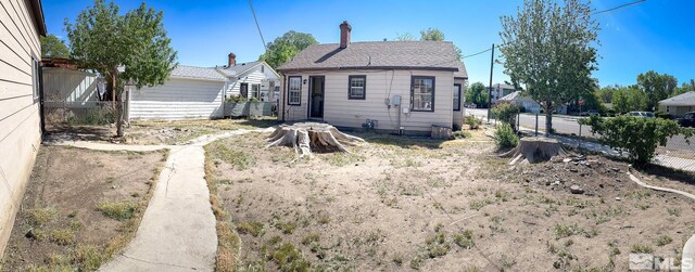 rear view of house with fence and a chimney
