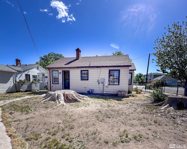 view of front of home featuring fence and a chimney
