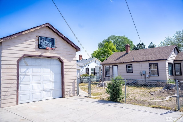 view of front facade with concrete driveway, a garage, fence, and a chimney