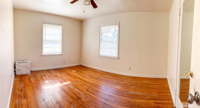 spare room featuring a ceiling fan, hardwood / wood-style flooring, and baseboards