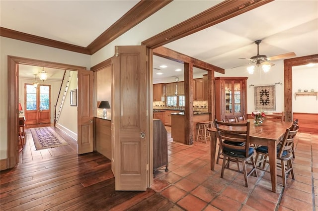 dining area featuring dark tile flooring, ornamental molding, and ceiling fan