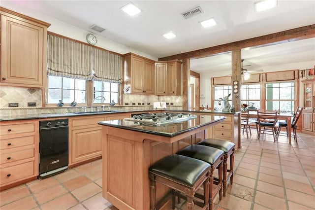 kitchen featuring ceiling fan, sink, a center island, and light tile floors