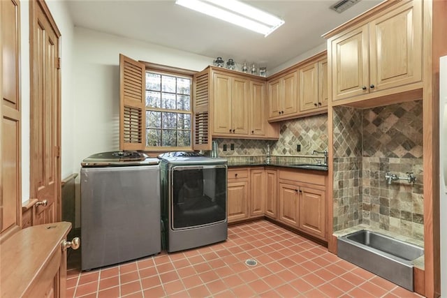 clothes washing area featuring light tile floors, cabinets, sink, and independent washer and dryer