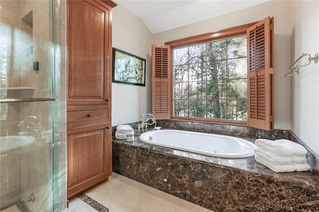 bathroom with lofted ceiling, shower with separate bathtub, and tile flooring