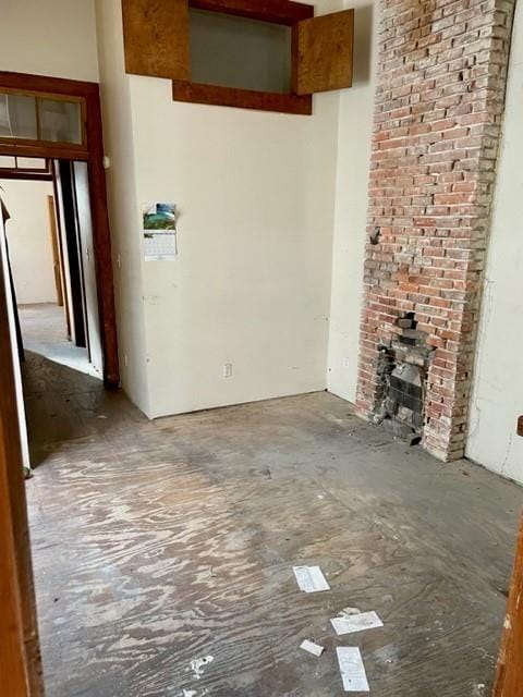 unfurnished living room with brick wall and a brick fireplace