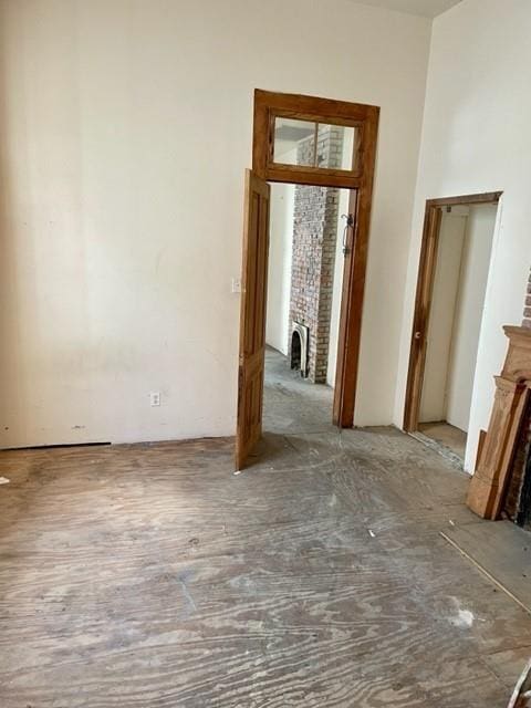 unfurnished bedroom with a brick fireplace, brick wall, and hardwood / wood-style floors