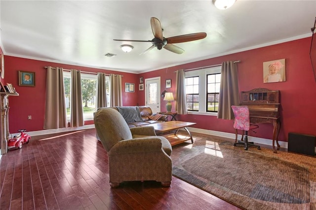 living room with dark wood-type flooring, ceiling fan, and crown molding