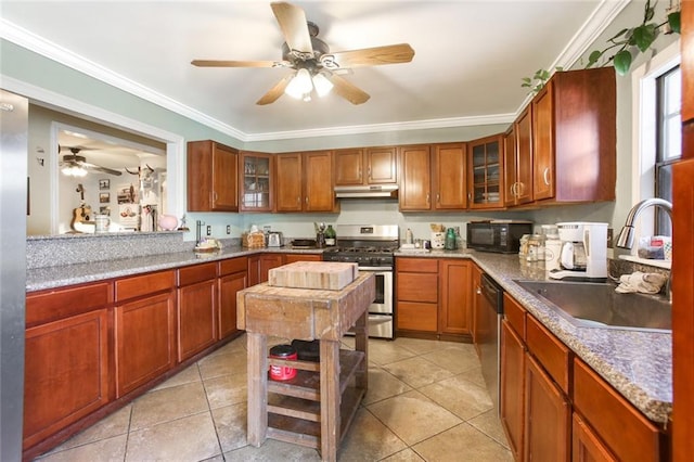 kitchen with appliances with stainless steel finishes, ceiling fan, sink, and light tile floors