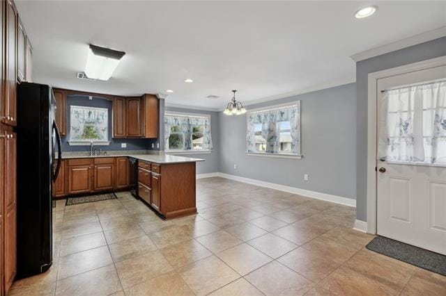 kitchen with light tile floors, a notable chandelier, black appliances, and pendant lighting