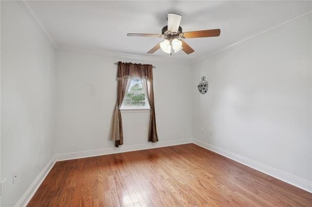 spare room featuring ceiling fan, hardwood / wood-style flooring, and crown molding