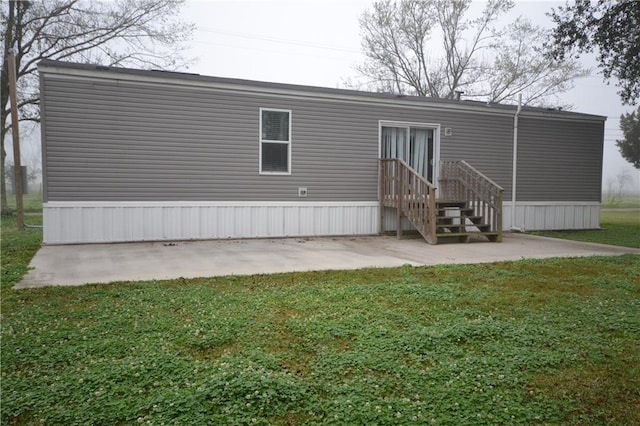 back of property with a lawn and a patio area