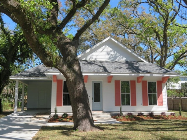 view of front of home with a front lawn, a carport, and a porch