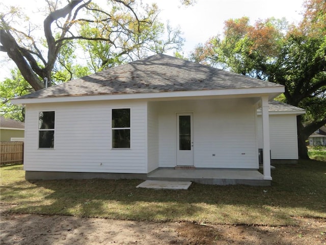 back of property with a lawn and a patio