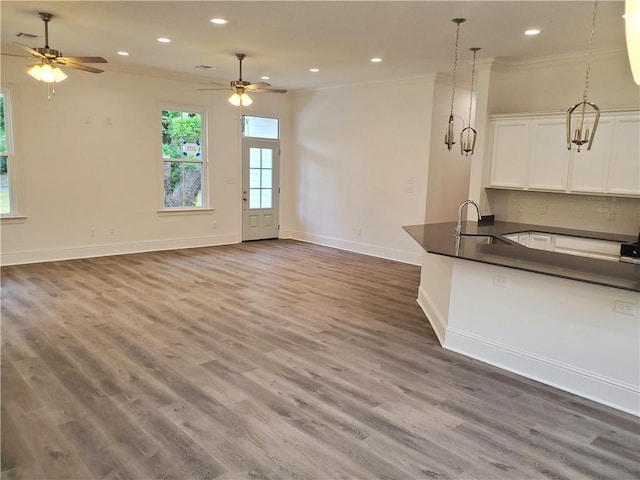 interior space with ceiling fan, dark wood-type flooring, sink, white cabinets, and tasteful backsplash