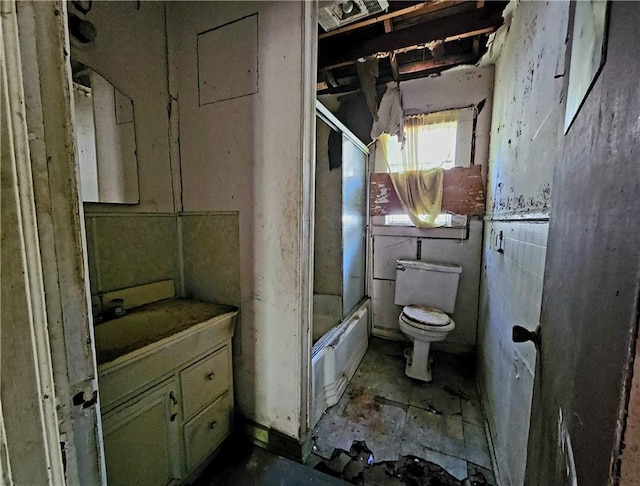 full bathroom featuring enclosed tub / shower combo, vanity with extensive cabinet space, and toilet