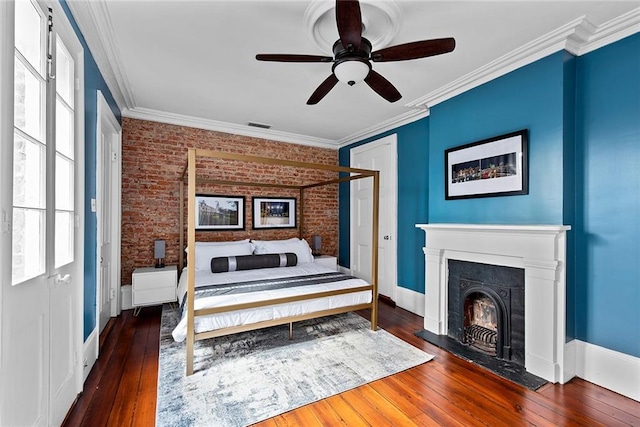 bedroom with ceiling fan, crown molding, dark wood-type flooring, and brick wall