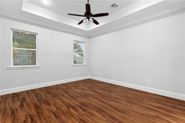 unfurnished room with ceiling fan, plenty of natural light, a tray ceiling, and dark wood-type flooring