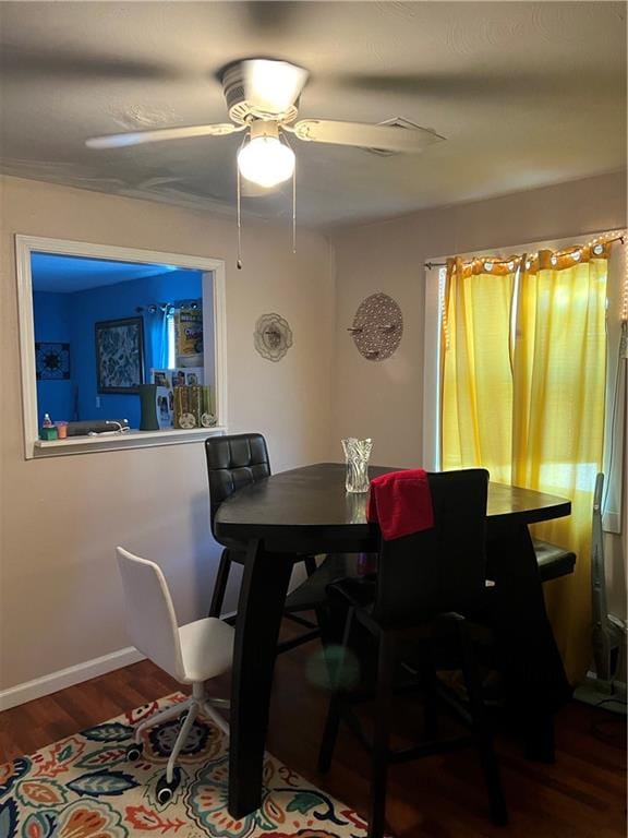 dining space featuring ceiling fan and dark wood-type flooring