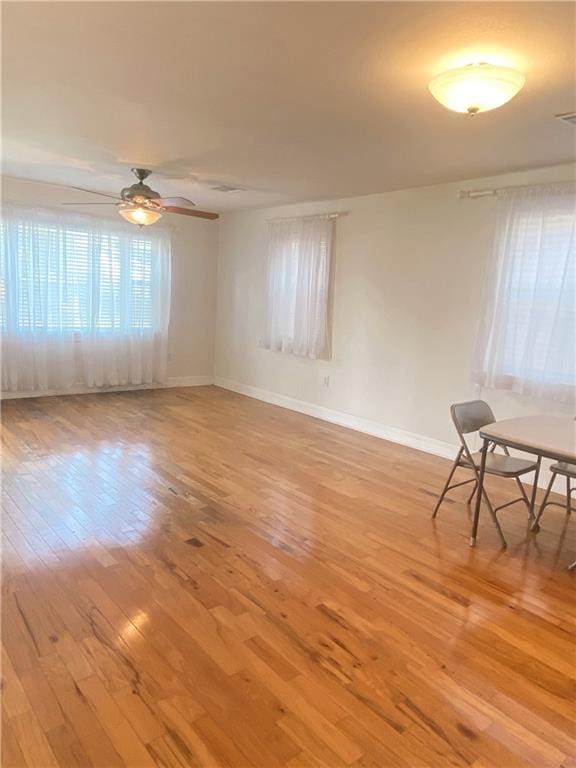 empty room with ceiling fan and light wood-type flooring