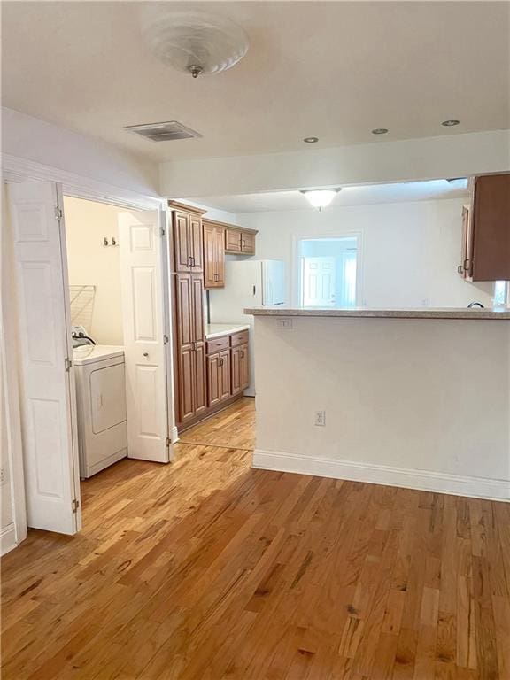 kitchen with separate washer and dryer and light hardwood / wood-style floors