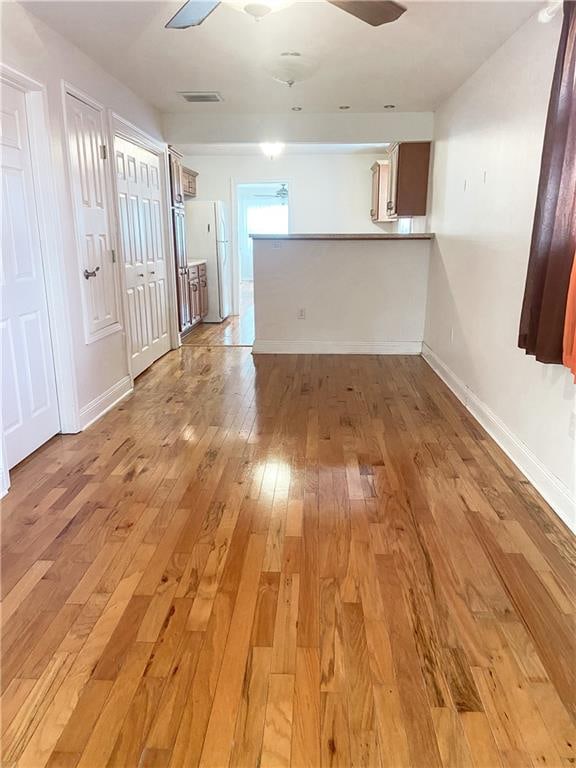 unfurnished room with ceiling fan and light wood-type flooring