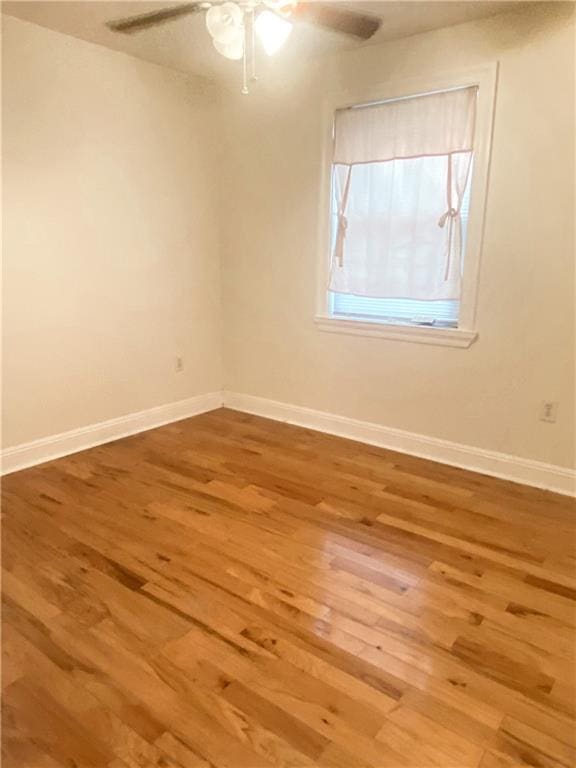 unfurnished room with ceiling fan and hardwood / wood-style flooring