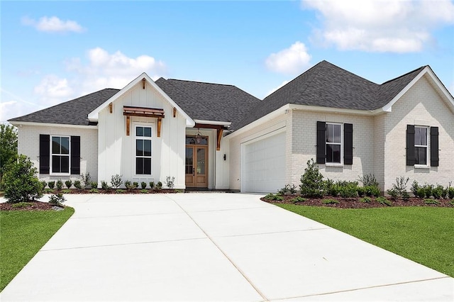 modern inspired farmhouse with a front yard and a garage