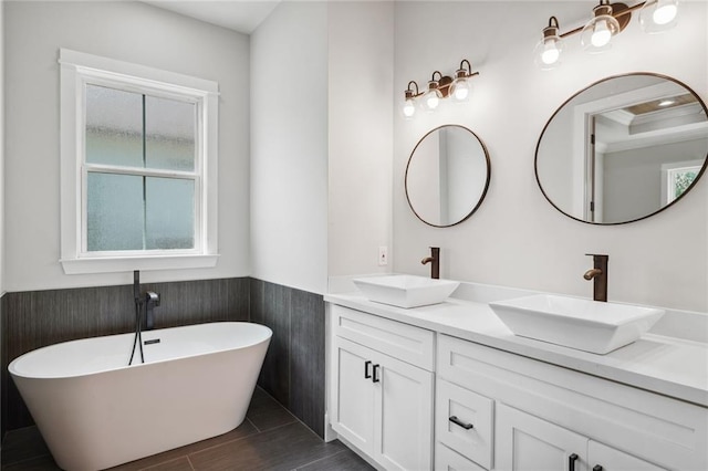 bathroom with dual bowl vanity and a bath