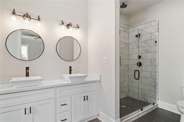 bathroom with double sink, oversized vanity, a shower with door, and toilet