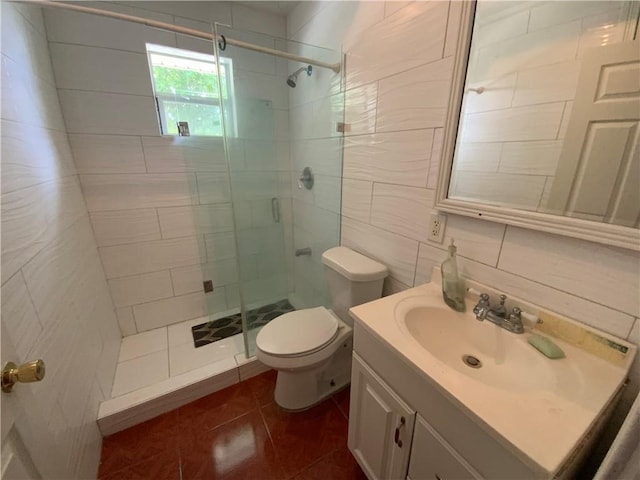 bathroom with tile flooring, tile walls, a shower with door, large vanity, and toilet