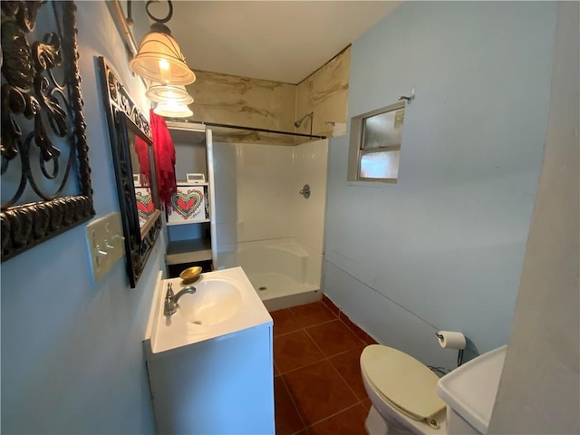 bathroom featuring a shower, toilet, tile floors, and vanity