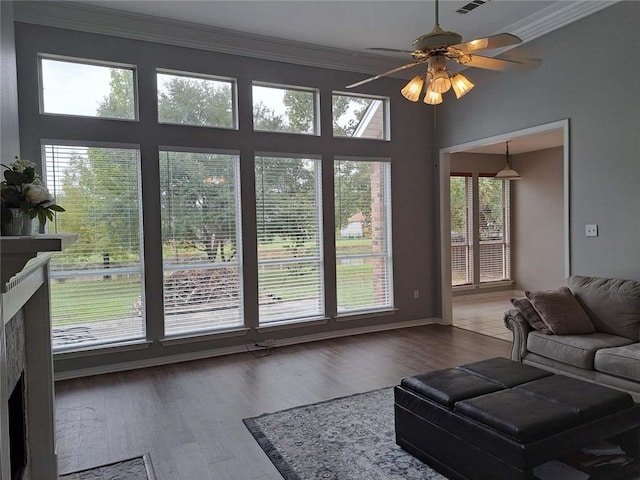 living room featuring ceiling fan, ornamental molding, and dark wood-type flooring