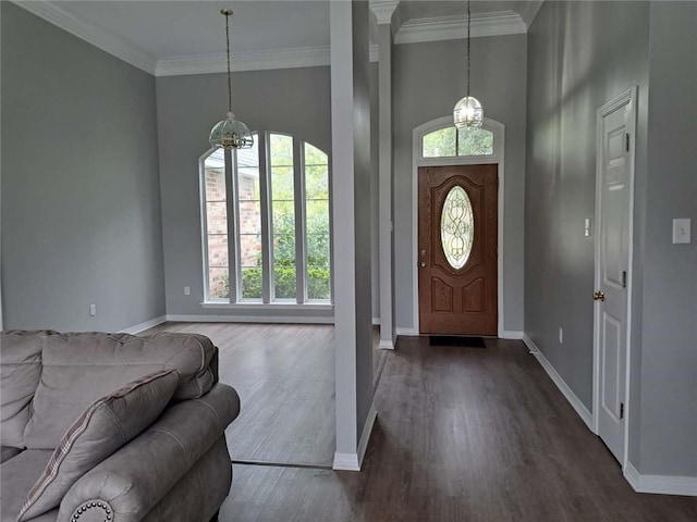 foyer entrance with crown molding, dark hardwood / wood-style flooring, a notable chandelier, and a high ceiling