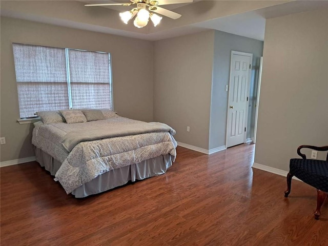 bedroom with dark hardwood / wood-style flooring and ceiling fan