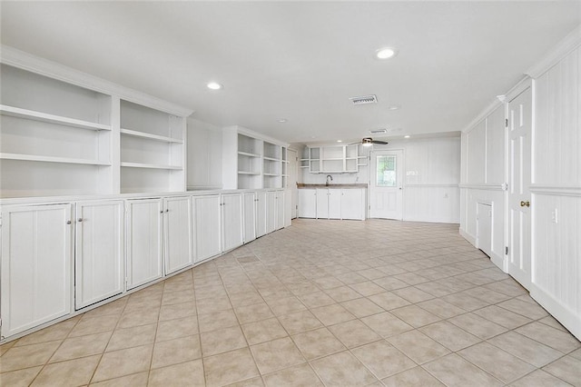 interior space featuring built in shelves, sink, and light tile flooring