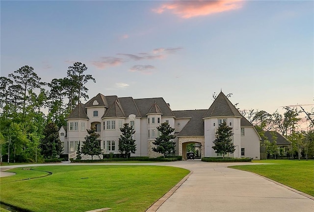 french country inspired facade featuring a yard