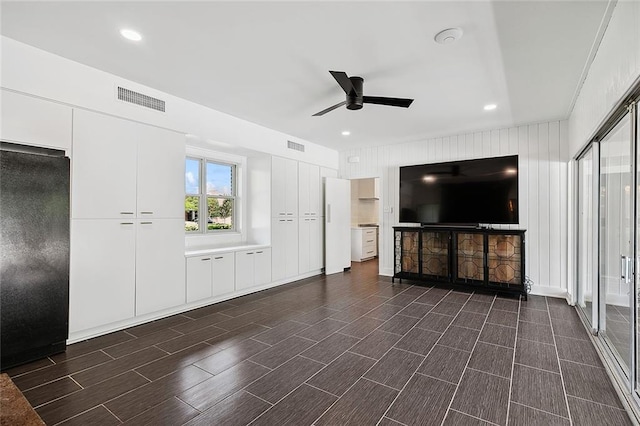 unfurnished living room featuring ceiling fan and dark hardwood / wood-style floors