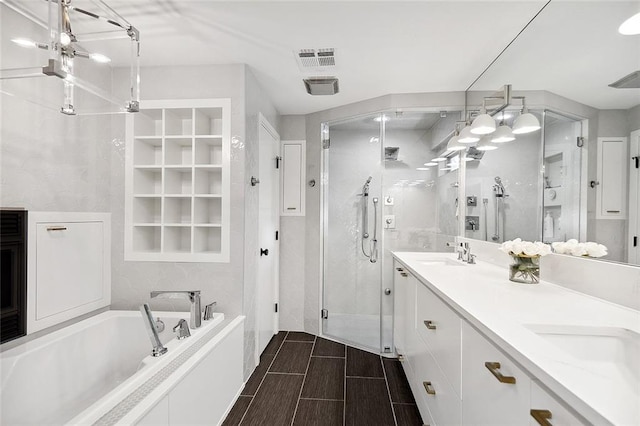 bathroom with plus walk in shower, tile floors, dual sinks, built in features, and large vanity