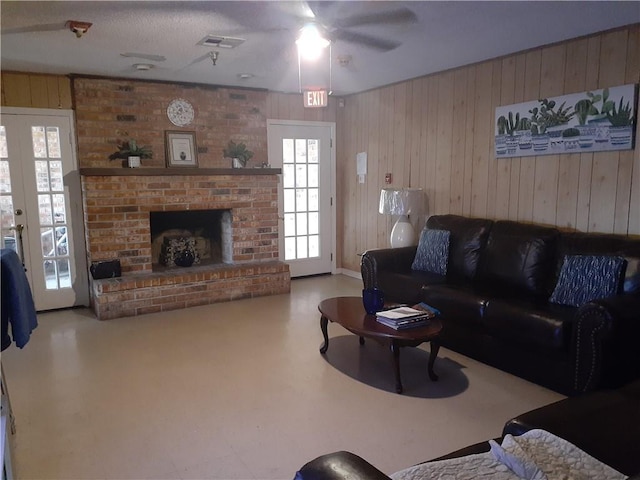 living room featuring french doors, brick wall, ceiling fan, and a brick fireplace