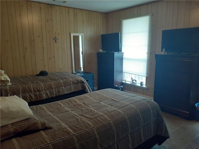 carpeted bedroom featuring wooden walls