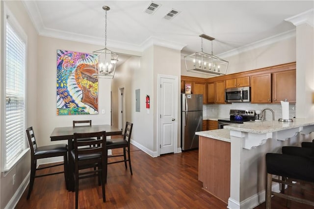 kitchen featuring decorative light fixtures, an inviting chandelier, dark hardwood / wood-style flooring, tasteful backsplash, and stainless steel appliances