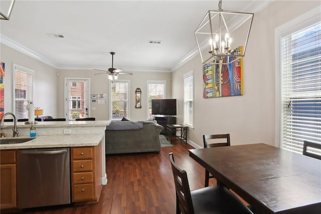 kitchen featuring dark hardwood / wood-style floors, pendant lighting, sink, stainless steel dishwasher, and ceiling fan with notable chandelier